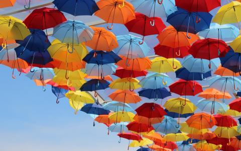 五颜六色的雨伞在天空中的壁纸