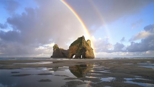 彩虹在海滩巨石壁纸