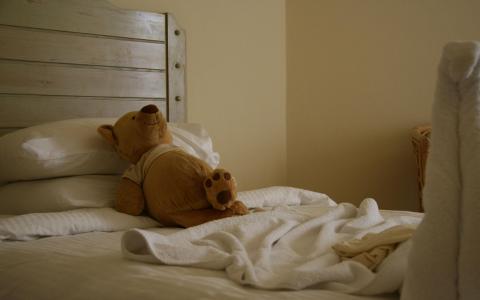 毛绒玩具熊躺在床上的壁纸