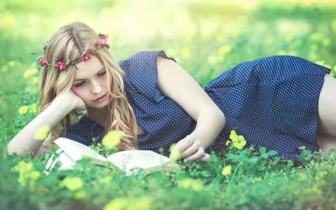 美丽的女孩读本书，花圈，草，鲜花壁纸