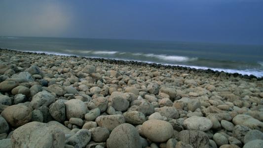 石海滩，波浪，黑暗的天空