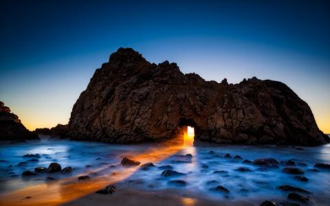 太阳光线，在岩石拱门，海滨