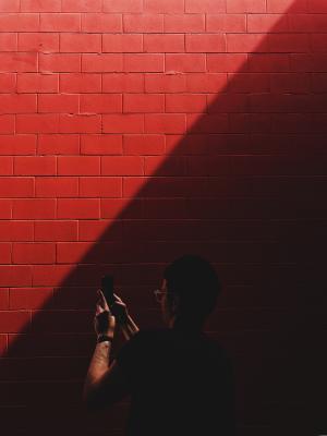 红色，墙壁，阳光，黑暗，人，男人，家伙，移动，手机，相机，摄影