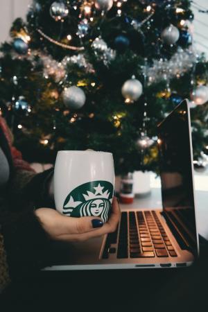 电脑笔记本电脑苹果笔记本电脑浏览器研究学习商业工作桌子手手人杯咖啡星巴克圣诞节树灯光球装饰品装饰假期季节