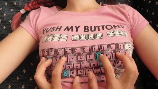 有趣的图像与胸部区域代表的T恤上的女孩，键盘，还有，在T恤上，它被写入_点击我的按钮_