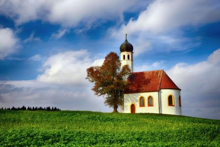 巴伐利亚南部的一座小教堂，一座小山，一棵树，一幅风景