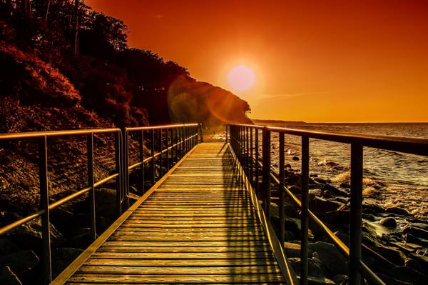 桥在日落期间的海洋旁边高清壁纸