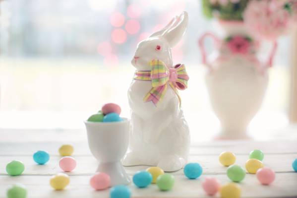 在蛋糖果旁边的白色陶瓷兔子小雕象HD墙纸