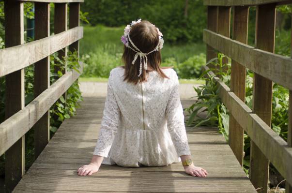 女人穿着白色的蕾丝礼服,坐在木桥高清壁纸