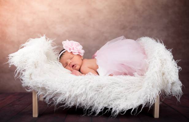 婴儿在粉红色的芭蕾舞短裙睡在白色的毛皮垫特写照片高清壁纸