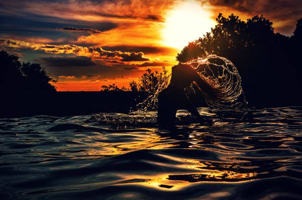 女人在日落时高清壁纸水体中的剪影照片
