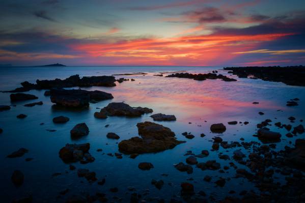 日落期间多岩石的海岸的照片高清壁纸