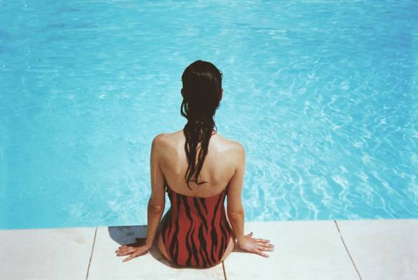 女人穿着黑色和橙色monokini游泳池附近高清壁纸