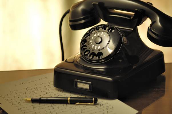 黑色旋转拨号电话旁边的黑色标志笔用棕色木制表面上的灰色纸高清壁纸