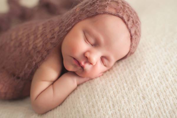 婴儿在棕色针织纺织睡觉躺在白色纺织高清壁纸