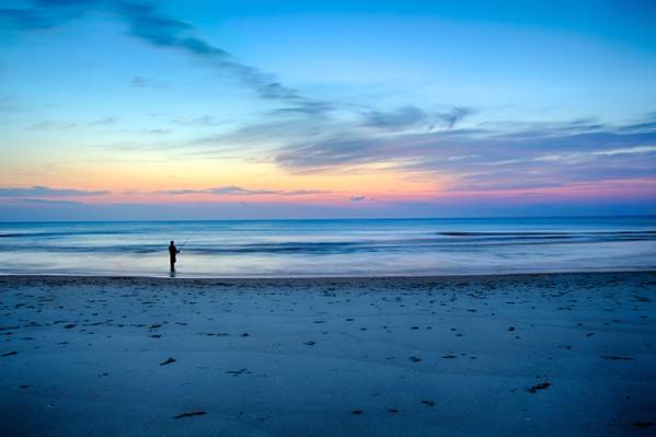人站在金色的小时高清壁纸附近的海洋的照片