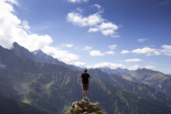男子在黑色t恤站在山下悬崖下蓝蓝的天空高清壁纸