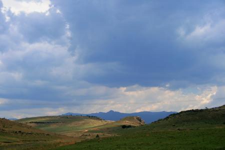 连绵起伏的丘陵, 褶皱, 绿脊, 远的蓝色山, 阴云密布, 天空, 云彩