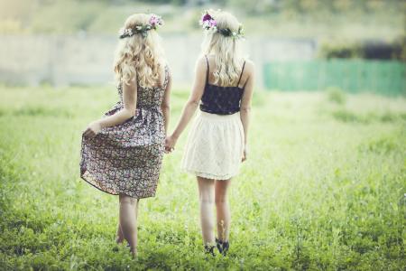 两个金发女郎正在草坪上散步