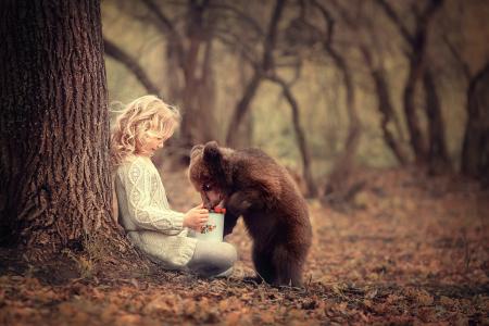 一个小女孩坐在一棵灰熊与一只灰熊