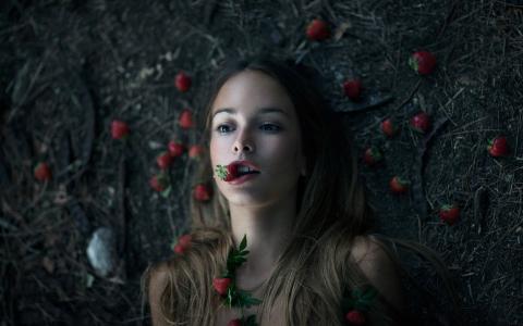 这个女孩躺在草莓地上
