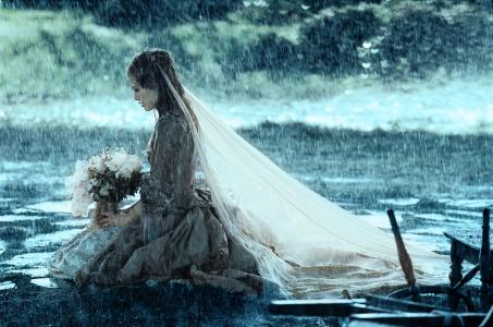 新娘在雨中坐在膝盖上