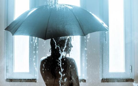 女孩在雨伞下变成了一个淋浴