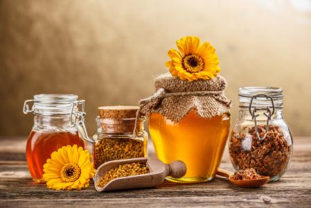 蜂蜜，花粉和蜂胶在桌子上的瓶子