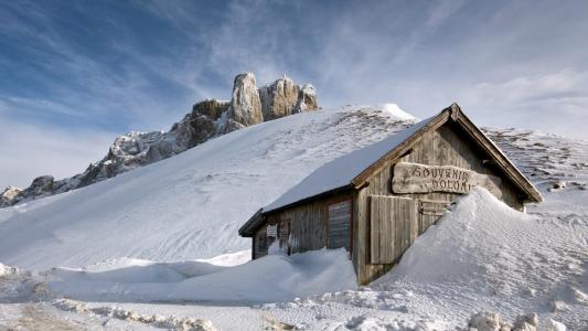 一座木屋被山上的积雪所取代
