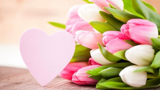 粉红色的郁金香和心的花束3月8日