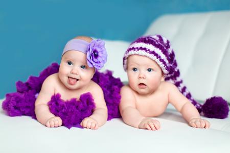 在美丽的紫色西装两个小有趣的婴儿