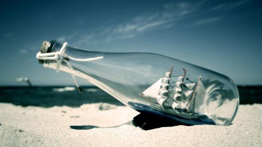 在海滩上的瓶子里的一艘船的图