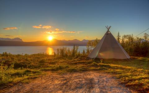 在日落时在湖的帐篷