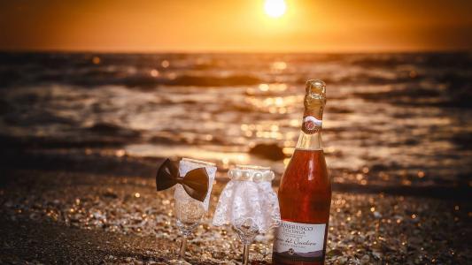 一瓶葡萄酒和两个沙滩上的眼镜