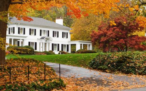 秋天包围的美丽的白色房子