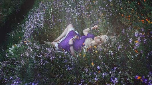 金发女孩躺在草地和鲜花